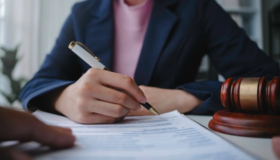 Lawyer is signing a last will and testament during a meeting with a client in their office