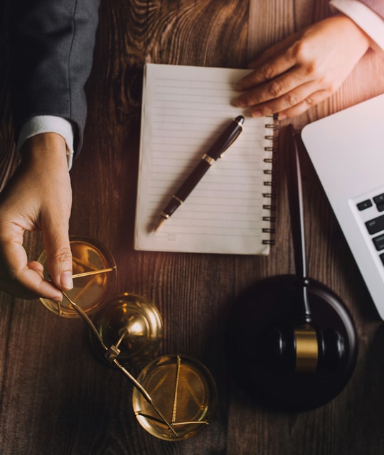 Business and lawyers discussing contract papers with brass scale on desk in office